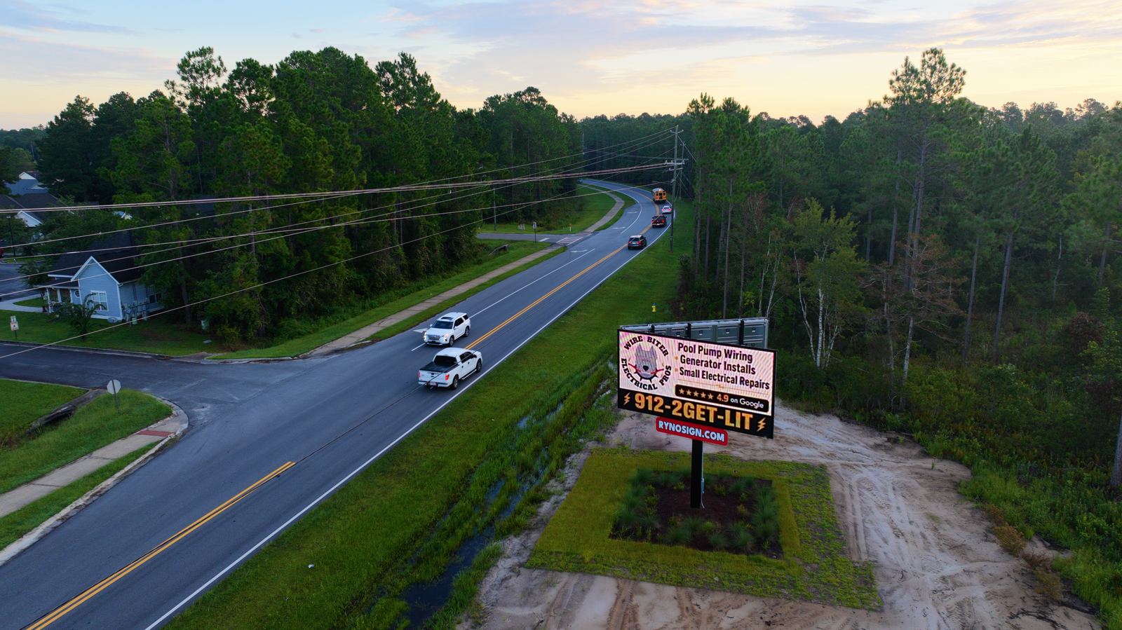 Billboard photographed at dusk beside the highway